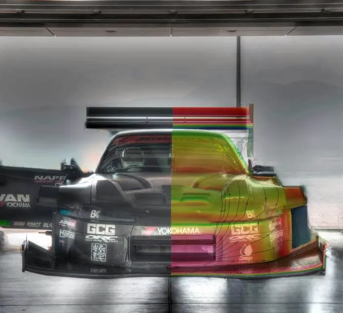 Front view of a race car split vertically, with the left half in natural black and the right half displaying colorful aerodynamic simulation overlays.